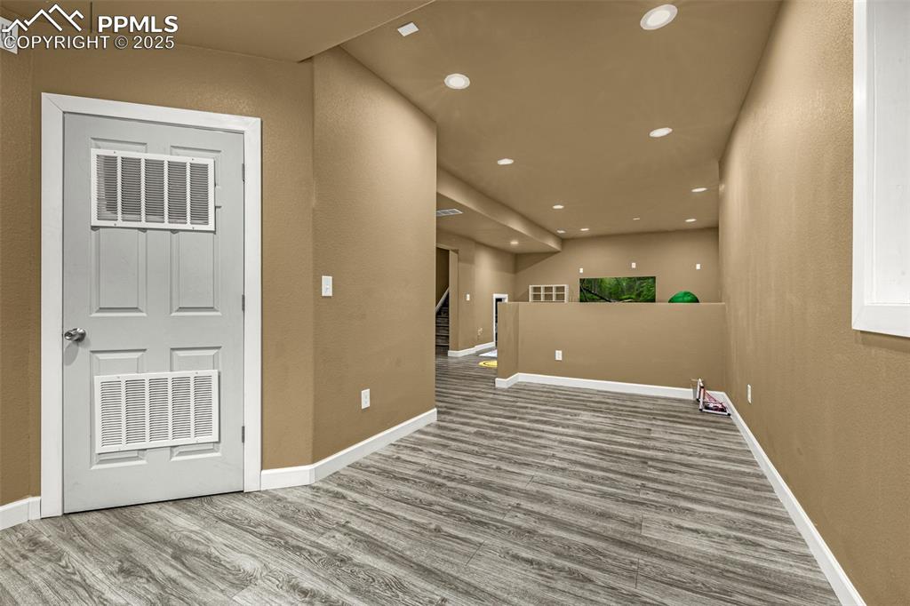 Spare room with recessed lighting, light wood-type flooring, stairway, and a textured wall