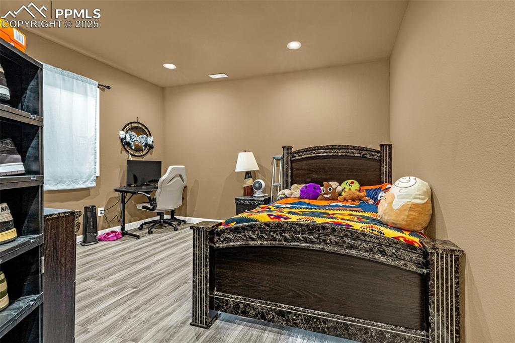 Bedroom with a desk, wood finished floors, and recessed lighting