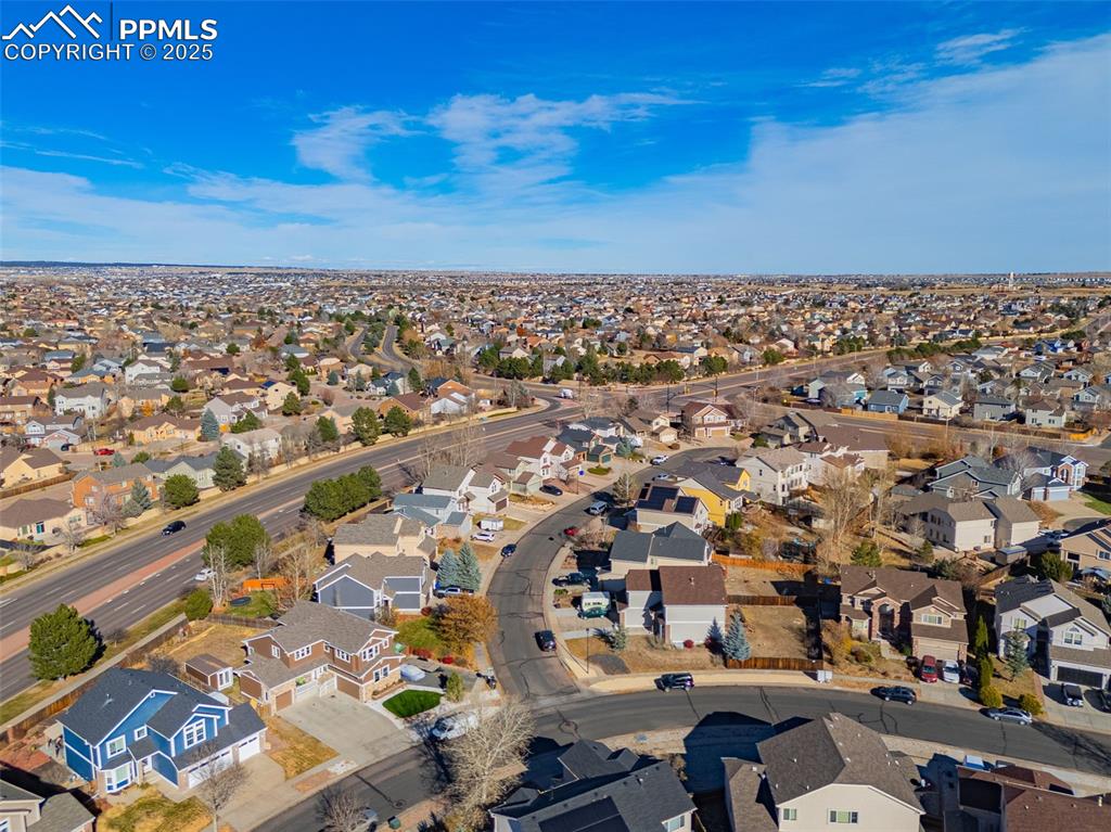 Aerial view of property and surrounding area featuring nearby suburban area
