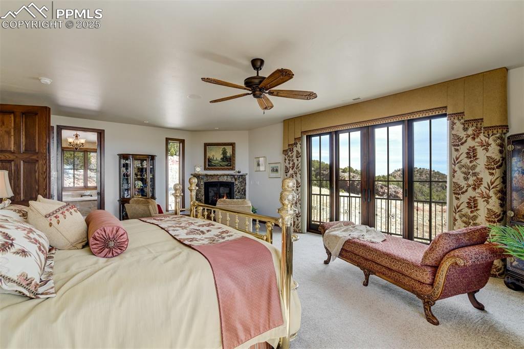 Gas fireplace with granite surround, seating area, and entrance to private balcony.