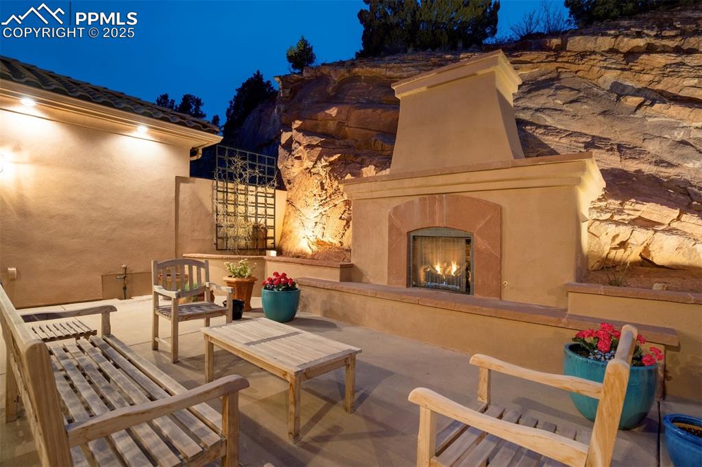Main patio with gas fireplace, large seating area & evening accent lighting