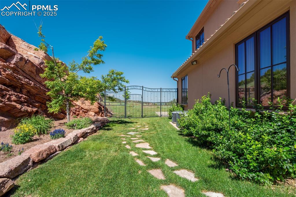 Back yard off of main patio w/ magnificent wrought iron gate!