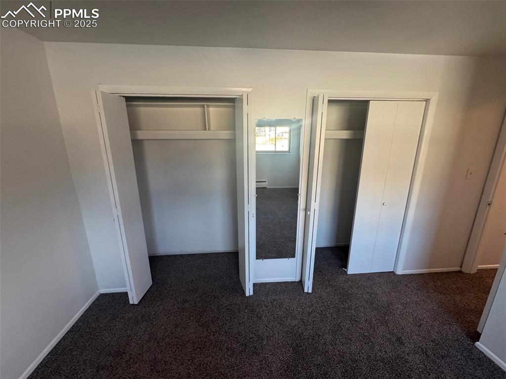 Unfurnished bedroom featuring two closets and new carpet