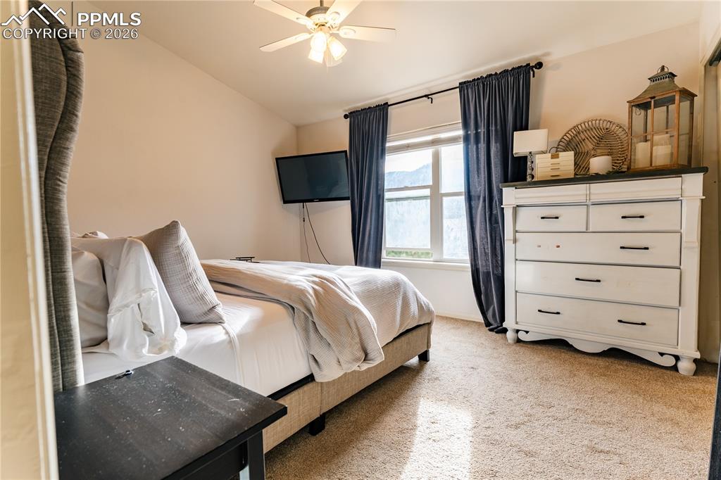Bedroom featuring light colored carpet, ceiling fan, and lofted ceiling