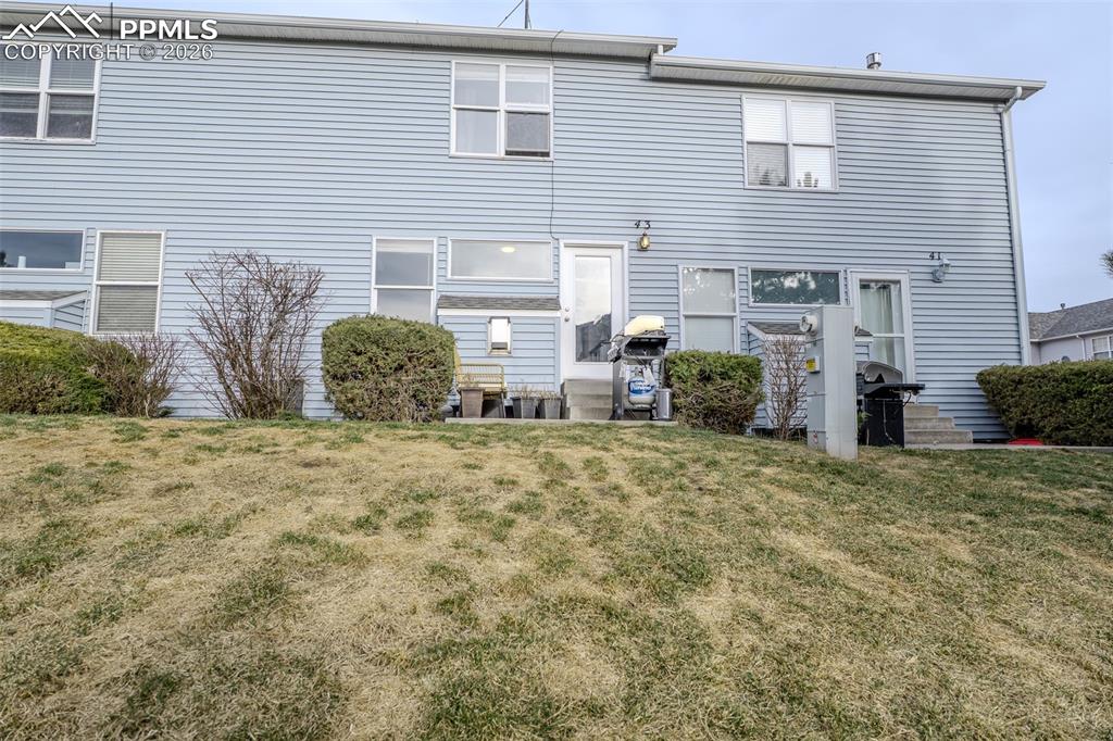 Back of house with a yard