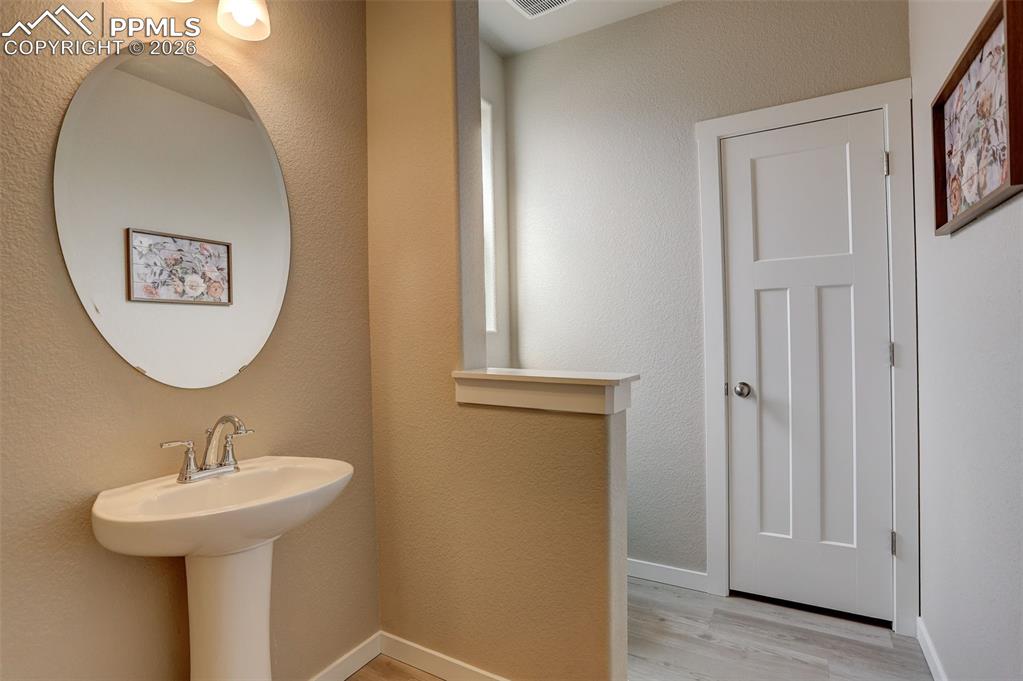 Main level Bathroom, pony wall, with pedestal sink, and linen closet - this bathroom is located  near the office, foyer and basement access