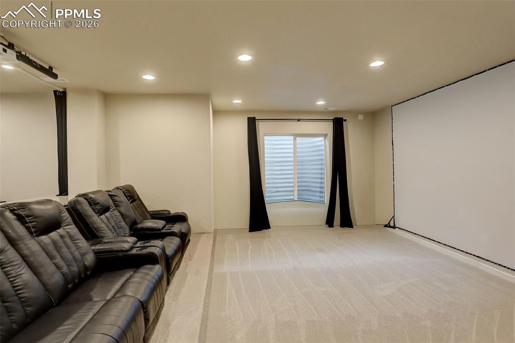 Theater area, with raised platform for theater seating, ceiling mounted projector, and large screen. Another storage closet!