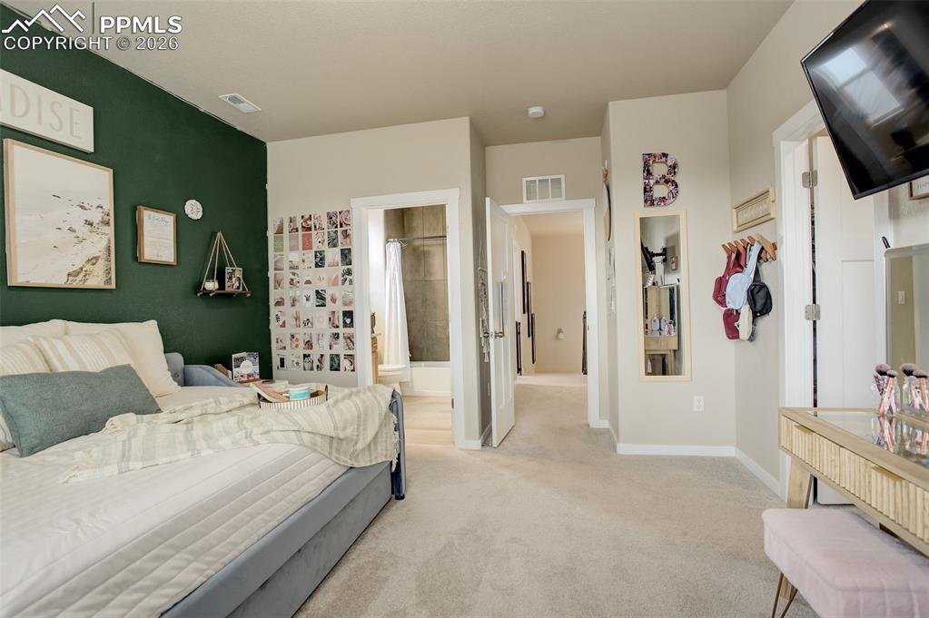 Adjoining bathroom. Full bathroom featuring stone vanity, shower/tub with tub to ceiling tile.