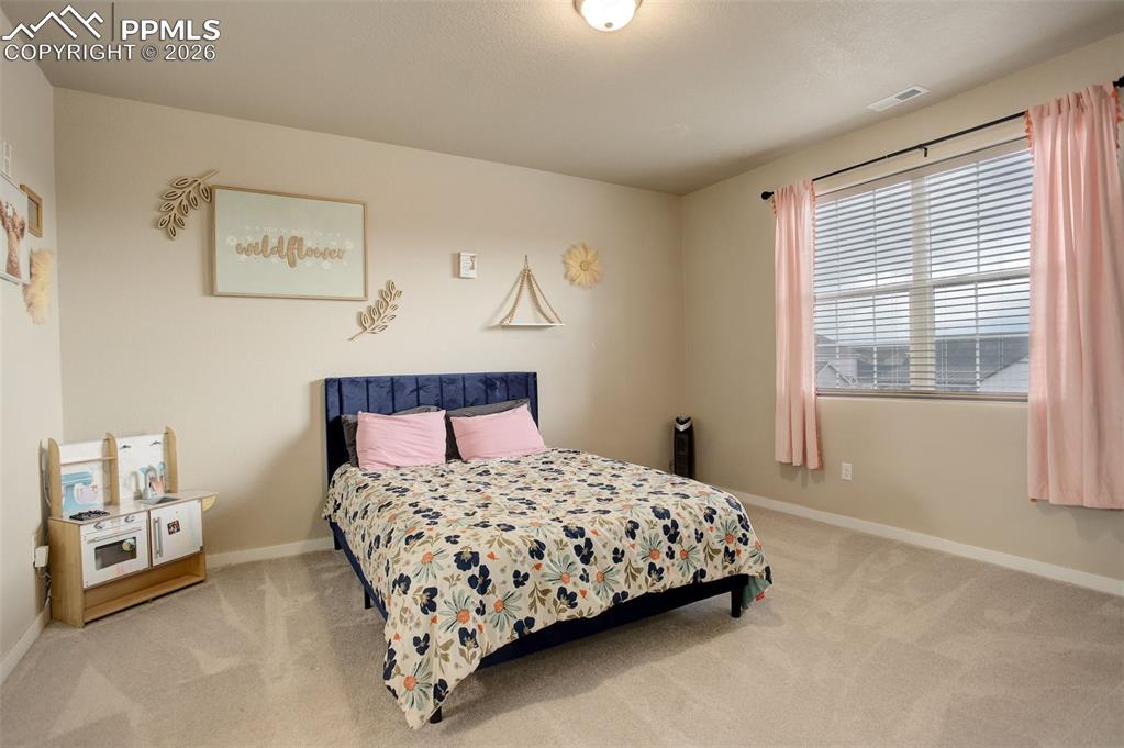 Bedroom with light carpet and ensuite bath
