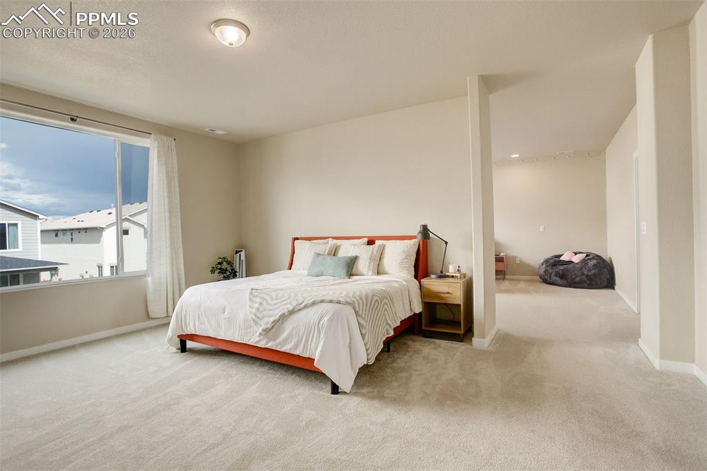 The upper-level primary suite is a true retreat, highlighted by a panoramic window that floods the space with natural light and frames expansive views. An attached flex space offers versatility and can be used as a sitting area, private study, home gym, or nursery. The suite features two spacious walk-in closets and a spa-inspired ensuite bath with a classic claw-foot soaking tub, a luxurious dual-entry shower with double shower heads, and separate vanities, creating a serene and indulgent escape.