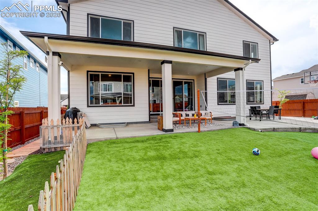 Rear view of house featuring a fenced backyard and a covered patio