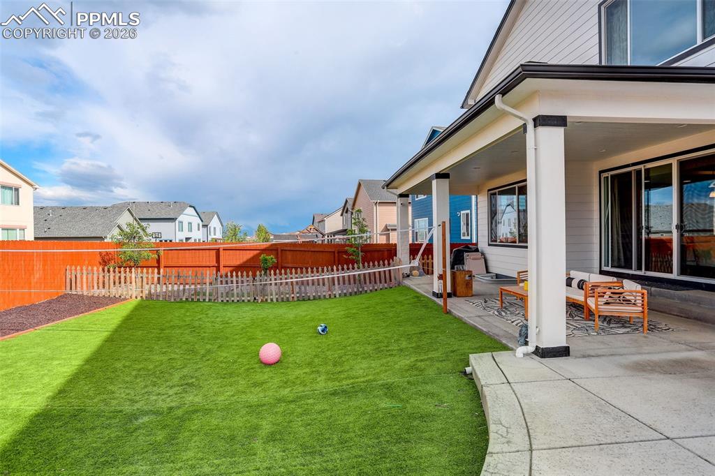 Fenced backyard featuring a patio area, turf - extended concrete patio. 