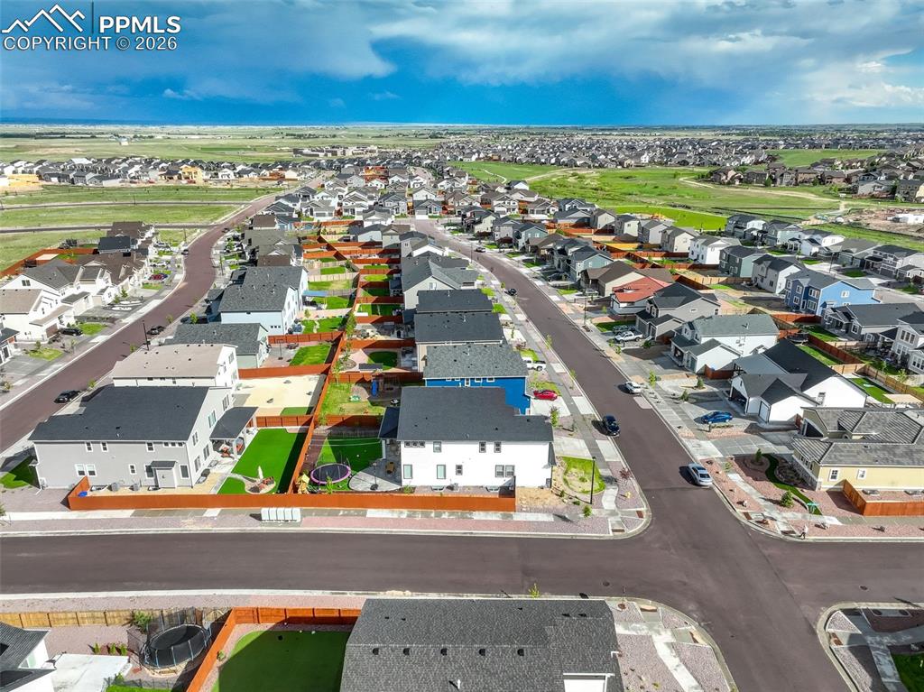 Aerial view of Craftsman house featuring two attached garages, concrete driveway, wood and stone siding. Charming entry porch. Modern Craftsman curb appeal.
