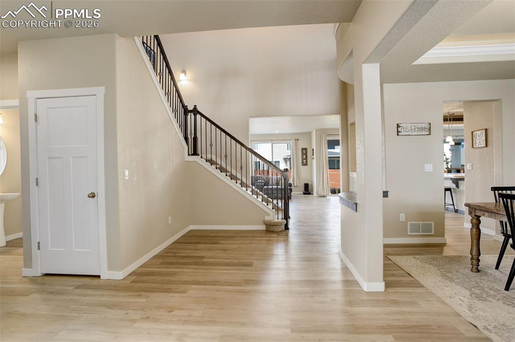 Foyer entrance featuring white oak LVP flooring, grand entry with 16+ft ceilings