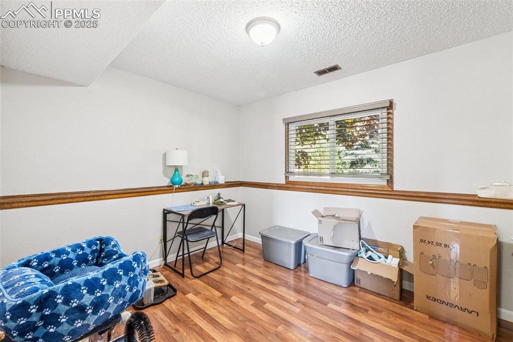 Miscellaneous room with light wood finished floors and a textured ceiling