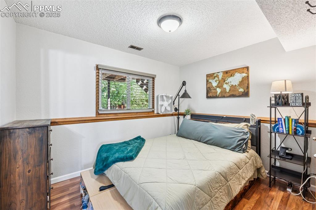 Bedroom with wood finished floors and a textured ceiling lower level