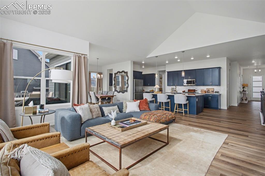 Living area featuring wood finished floors, a high ceiling, and recessed lighting