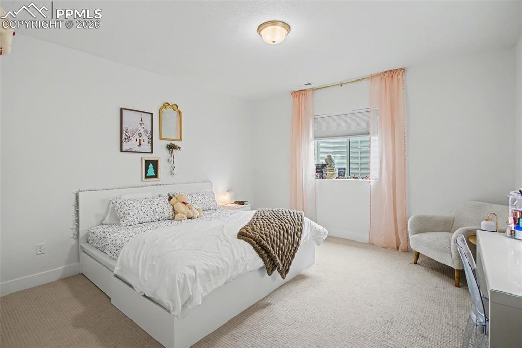 Bedroom featuring light carpet and baseboards