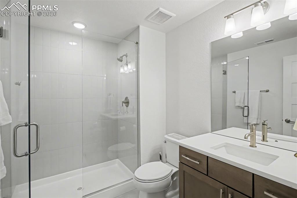 Bathroom featuring vanity and a shower stall