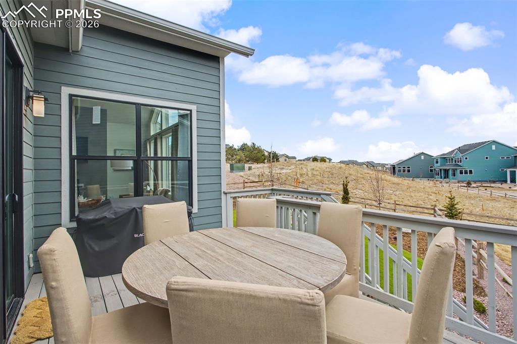 View of wooden balcony with outdoor dining area, a wooden deck, and area for grilling