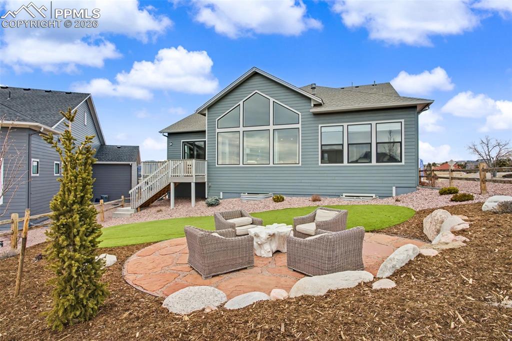 Back of house featuring a patio, an outdoor hangout area, a shingled roof, and a deck