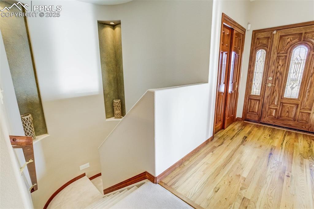 Curved stairway with inset details lead to the finished basement 