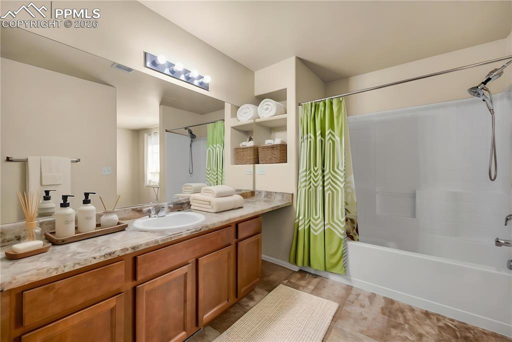 Spacious full bath with extended vanity, tile floors, and modern lighting.