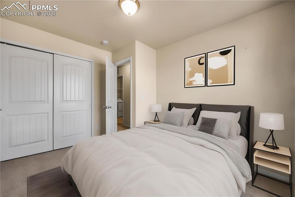 Bedroom with an office area, light carpet, and a closet