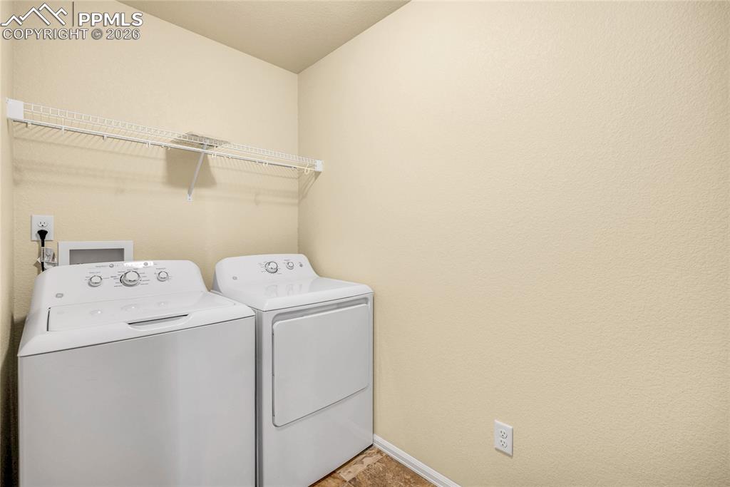 Upstairs laundry area with full-size washer and dryer, plus overhead shelving.
