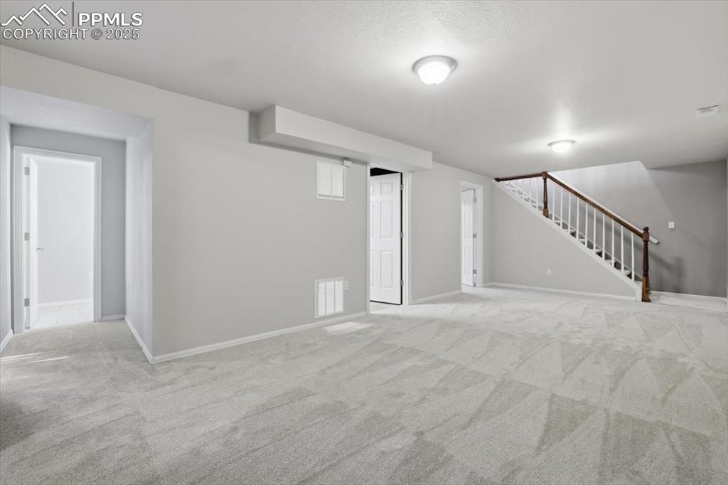 Basement featuring carpet floors and stairway