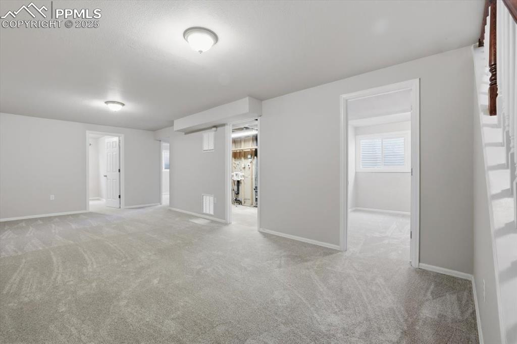 Spare room featuring light carpet and baseboards