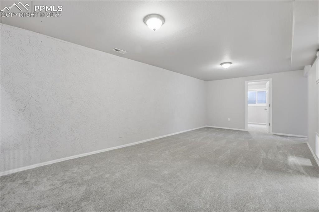 Spare room featuring carpet floors and a textured wall