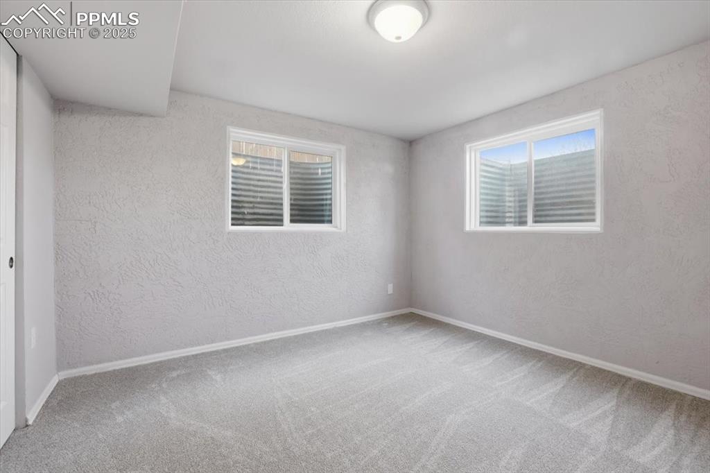Spare room featuring a textured wall and carpet flooring