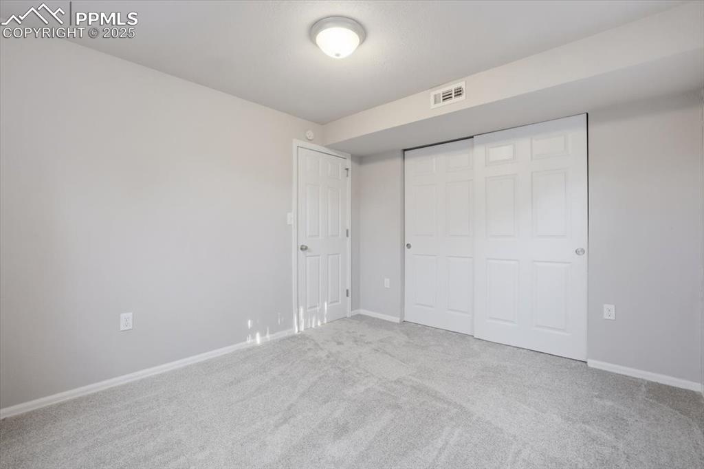 Unfurnished bedroom featuring carpet and a closet