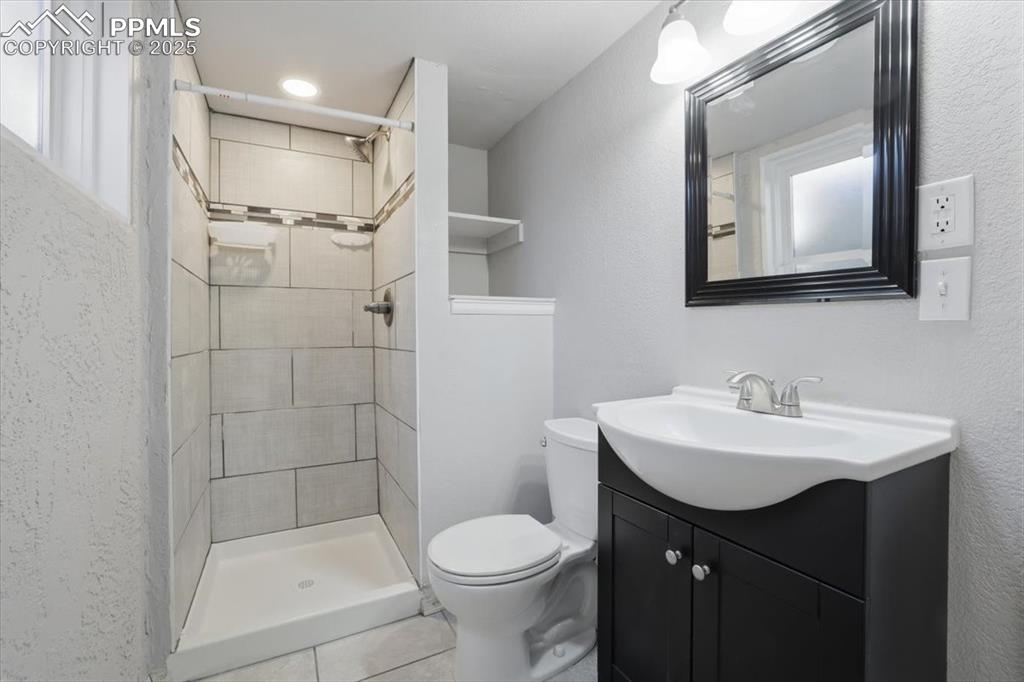 3/4 bath in basement with tile flooring and shower