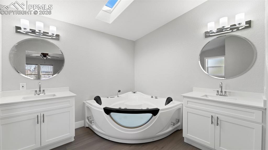 Bathroom with vanity, a tub to relax in, and hardwood / wood-style floors