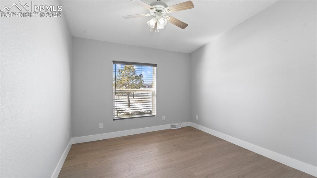 Spare room with hardwood / wood-style flooring and ceiling fan