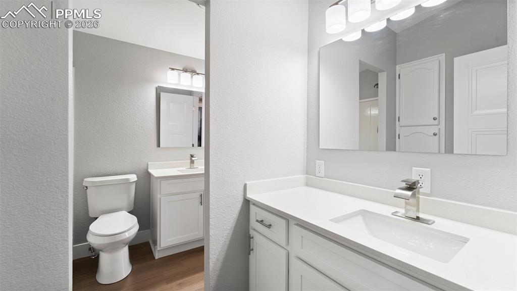 Bathroom with vanity, wood-type flooring, and toilet