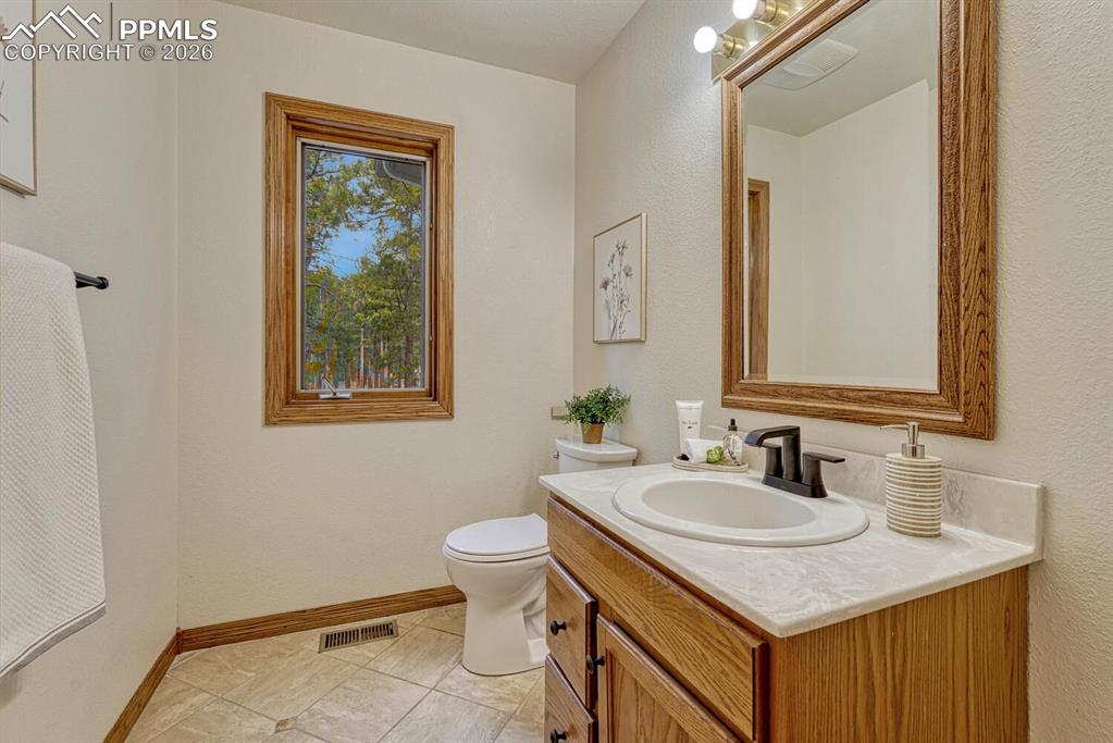 Convenient Powder Bathroom with vanity and framed mirror.