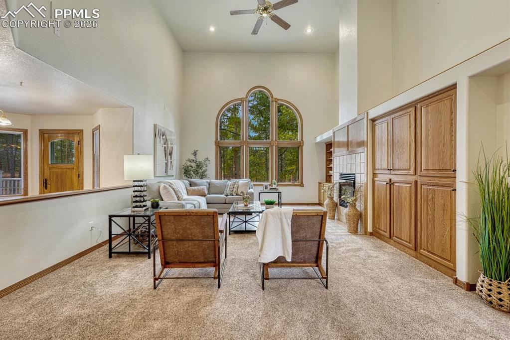 The inviting Family Room has high ceilings, a lighted ceiling fan, and plush neutral carpet.