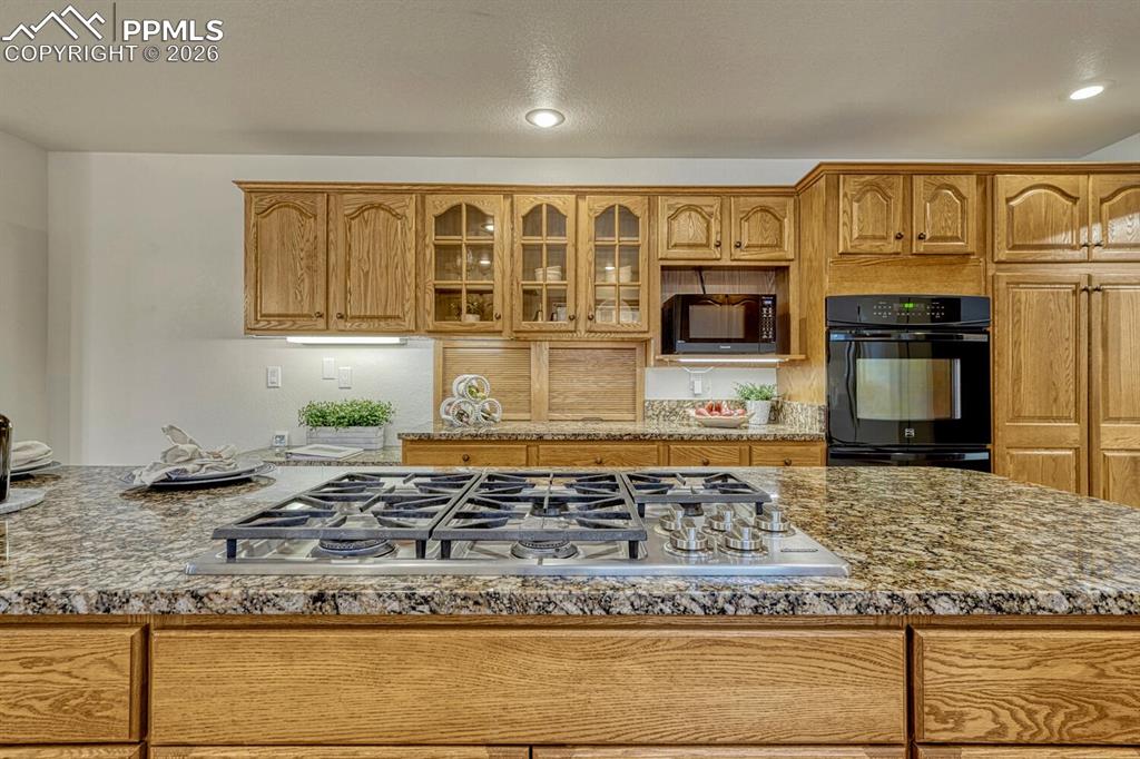 Appliances include a gas cook top, double ovens, dishwasher, microwave, and refrigerator.
