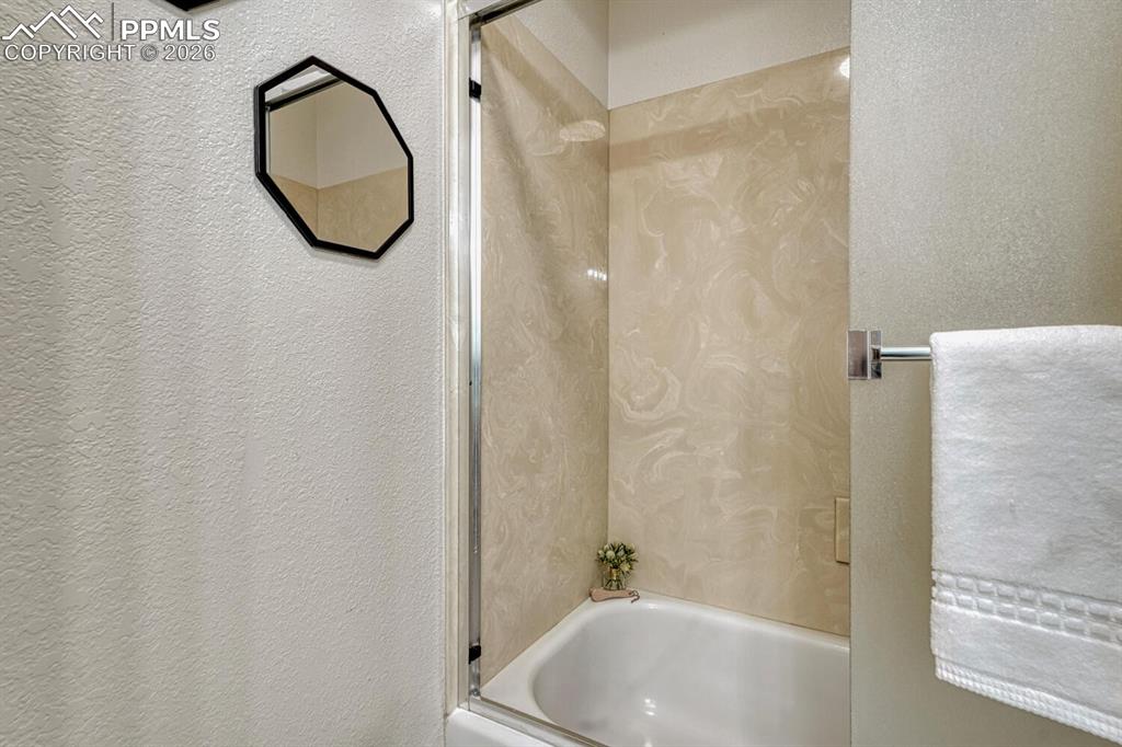 Tiled tub/shower in the upper level Hall Bathroom.