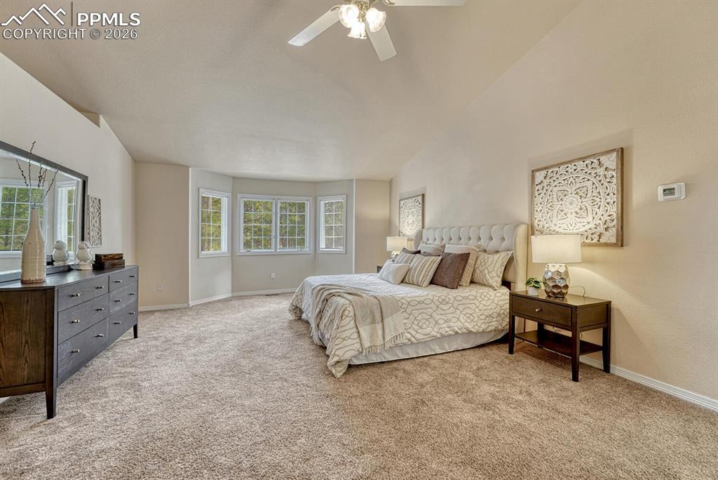 The Primary Bedroom has neutral carpet, a lighted ceiling fan, and bay window.