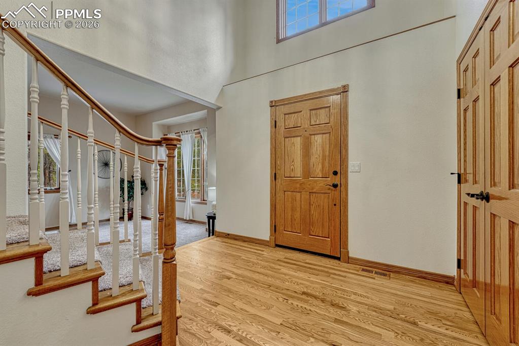 Front foyer with soaring ceilings and gleaming hardwood floors.