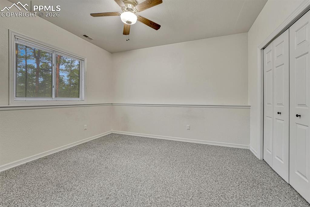 Basement Bedroom #5 has neutral carpet, a lighted ceiling fan, and generous closet.