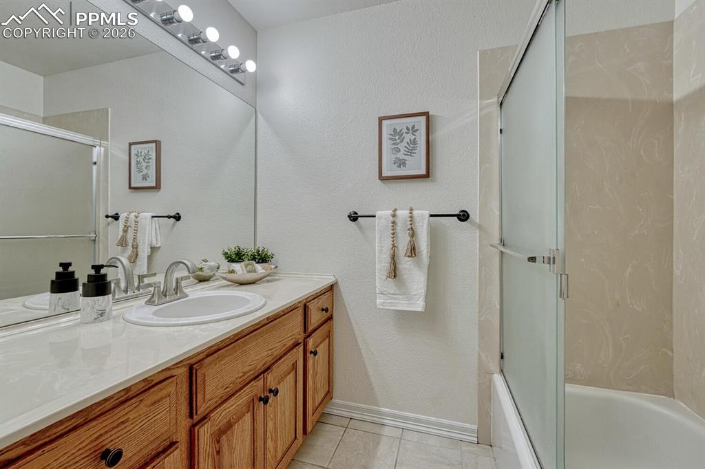 Full Basement Bathroom with vanity, mirror, and tiled tub/shower.