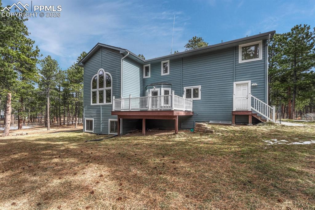 Rear view of home and backyard with composite deck.