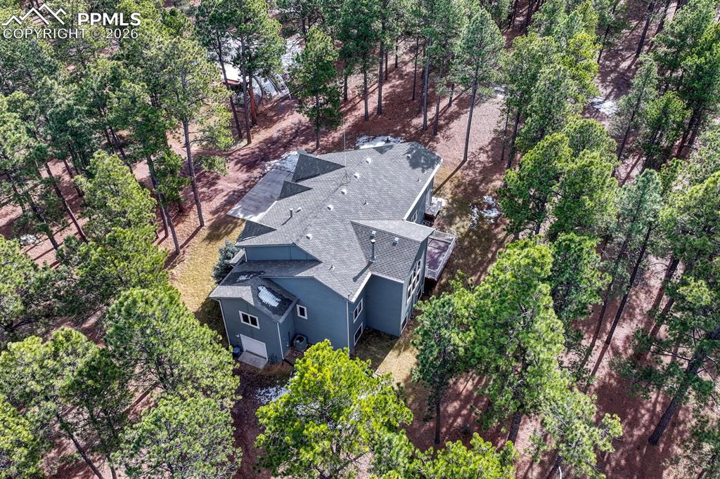Aerial view of home and treed lot.