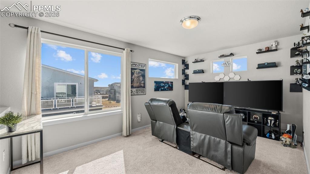 Home theater featuring light carpet and baseboards