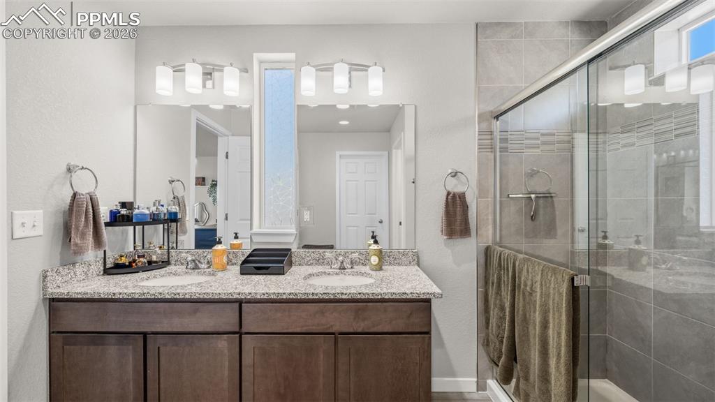 Bathroom featuring double vanity and a stall shower